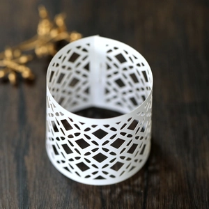 Detailed view of white laser-cut geometric diamond pattern on a decorative cylinder cover