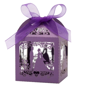 Detail of laser-cut purple gift box with romantic wedding silhouette and ribbon
