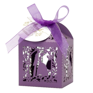 Macro detail of laser cut purple candy box with groom and bride silhouette and ribbon