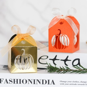 Macro detail of laser-cut pumpkin candy boxes with ribbons for Halloween and weddings