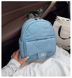 Detailed view of light blue quilted denim shoulder bag with silver metallic twist lock