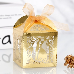 Dettaglio della scatola per confetti dorata tagliata al laser con motivi floreali e nastro