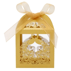 Detail of laser-cut peacock pattern on golden wedding favor box with a satin ribbon bow