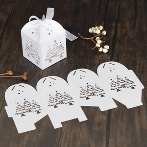 Detail der lasergeschnittenen Weihnachts-Geschenkbox mit weißem Band auf dunklem Holz