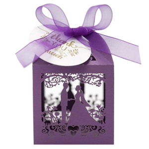 Macro detail of laser-cut purple wedding favor box with ribbon and thank you tag