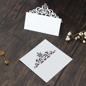 Détail du carton de table découpé au laser en papier perlé blanc avec motif croix élégant