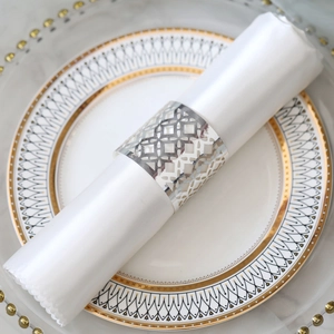 Macro detail of a silver hollow geometric napkin ring on a white fabric napkin
