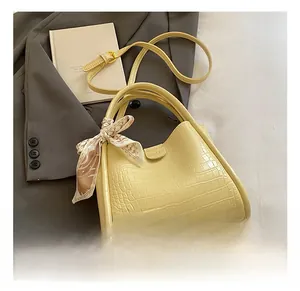 Détail du sac seau jaune clair gaufré crocodile avec un foulard en soie décoratif