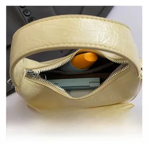 Vue intérieure du sac demi-lune jaune montrant l'espace de rangement pour cosmétiques