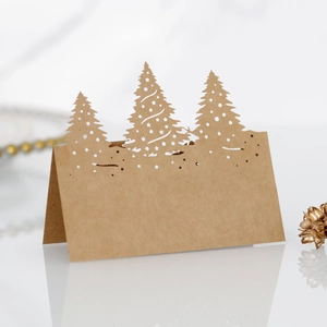 Vue macro de marque-places de Noël en papier kraft découpé au laser sur marbre blanc