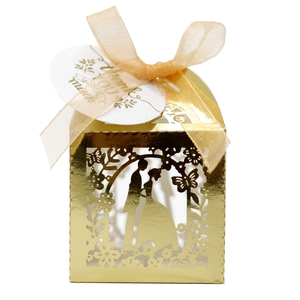 Close-up of laser-cut gold wedding favor box with ribbon and thank you tag detail