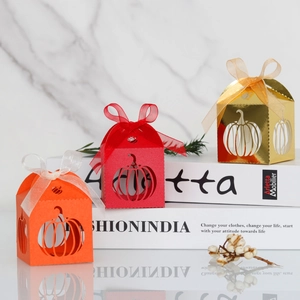 Three pumpkin laser cut favor boxes in orange red and gold with silk ribbons
