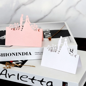 Detailed laser-cut wedding place cards in pink and white with floral silhouette