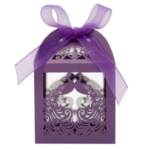Detail of purple laser-cut gift box with peacock pattern and organza ribbon bow