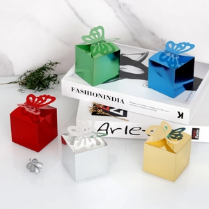 Detailed view of colorful laser-cut mirror butterfly gift boxes for wedding favors