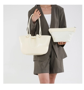 Elegante borsa tote bianco crema e pochette coordinata indossata da modella in tailleur