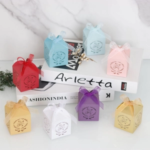Boîtes à bonbons de mariage découpées au laser avec motifs de roses et rubans de soie colorés