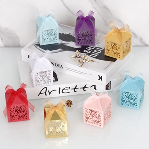 Vue détaillée des boîtes à bonbons de mariage découpées au laser avec des nœuds en satin