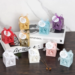 Laser-cut wedding favor boxes with ribbon bows and thank you tags in various colors
