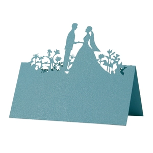Detail of laser cut wedding place card in light blue featuring a couple silhouette