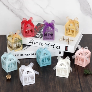 Laser cut heart wedding favor boxes in various colors with ribbon bows for guests