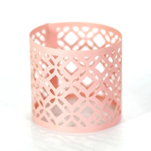 Detail of laser-cut geometric diamond pattern on light pink paper cupcake wrapper