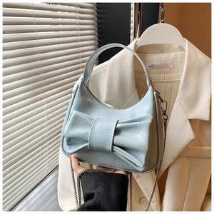 Gros plan sur le sac croissant bleu ciel avec un grand nœud décoratif et une chaîne