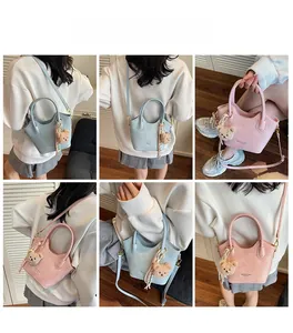 Vedute multiple di una mini borsa a mano con un simpatico ciondolo a forma di orsetto