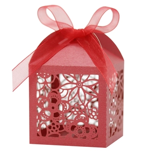 Detail of red laser-cut candy box featuring floral patterns and a matching satin ribbon bow