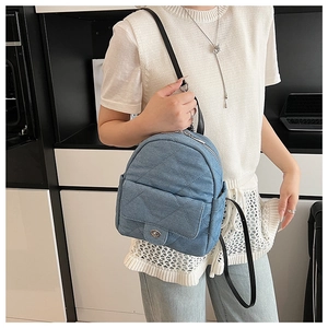 Quilted denim mini backpack in light blue with silver twist lock on the front pocket