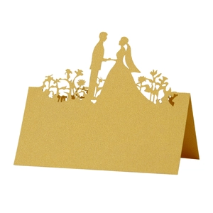Laser cut gold place card for weddings featuring a bride and groom silhouette decoration