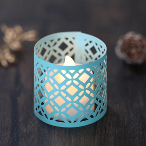 Hollow geometric light blue candle shade with warm LED electronic tea light candle