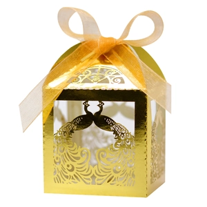 Detail showing laser-cut peacock pattern on golden wedding candy box with ribbon