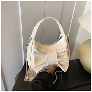 Détail du sac beige à nœud en cuir texturé avec bandoulière en chaîne argentée