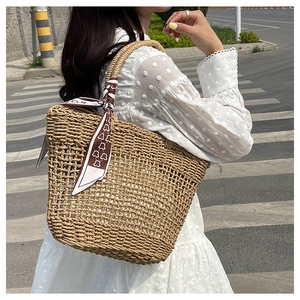 Detailed close-up of handmade straw tote bag with a patterned scarf and lace dress detail