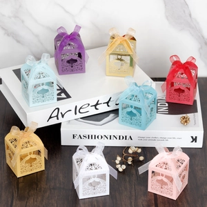 Laser-cut peacock candy boxes with organza ribbons in various vibrant colors for wedding