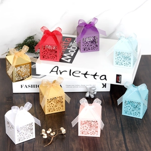 Detail of laser-cut floral candy boxes with ribbons in various elegant colors