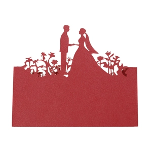 Macro shot of red laser-cut wedding place cards showing bride and groom silhouette