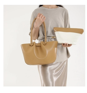 Set borsa tote in pelle marrone con manici annodati e pochette bicolore abbinata sul modello