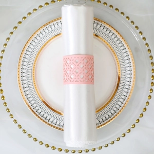 Detail of pink laser-cut hollow napkin ring with geometric patterns for party decor