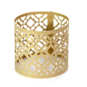 Detailed macro view of laser-cut gold paper napkin ring with elegant geometric patterns