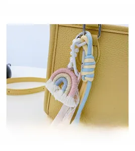 Detail of colorful rainbow woven pendant with pearls on yellow lychee texture handbag