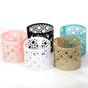 Macro shot of geometric hollowed laser-cut napkin rings in five metallic colors