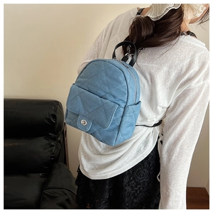 Detail of light blue denim mini backpack with diamond quilting and silver twist lock