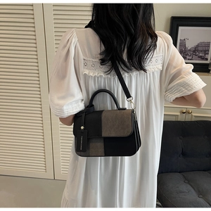 Detailed back view of a woman wearing the contrast color patchwork leather handbag