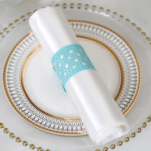 Macro detail of laser-cut light blue napkin ring with hollow geometric patterns