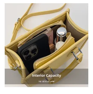 Top view of yellow lychee leather mini tote showing inner compartments with daily items
