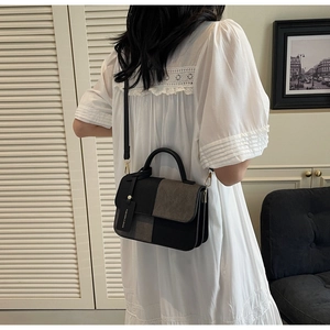 Detail of the minimalist color-block handbag showing texture and hanging fashion tag