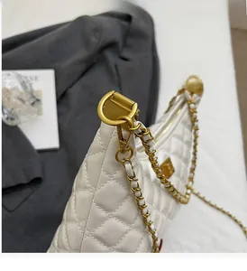 Detail of cream quilted leather shoulder bag featuring gold chain and D-ring buckle