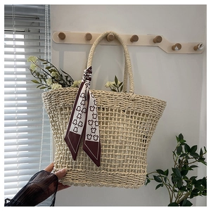 Detail of hollow woven tote bag with red printed silk scarf on a wooden wall hook